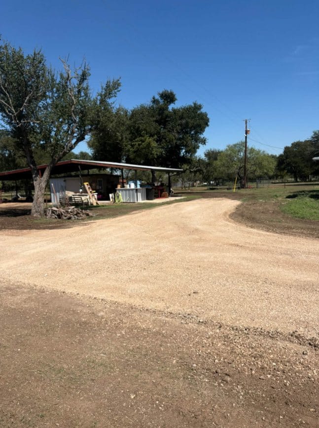 Finished gravel drive curving past a covered patio