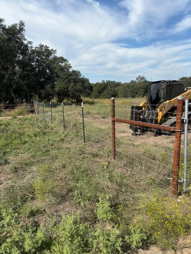 Skid steer on site while building a wire fence